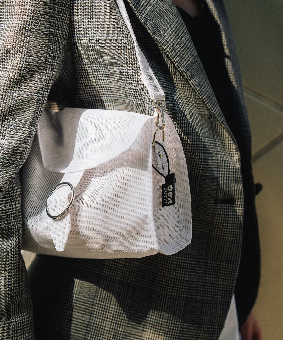 Detalle de un bolso blanco de marca llevado con una americana de cuadros (imagen provisional).