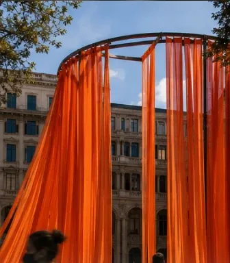 Instalación textil naranja a gran escala en una plaza urbana (imagen provisional).